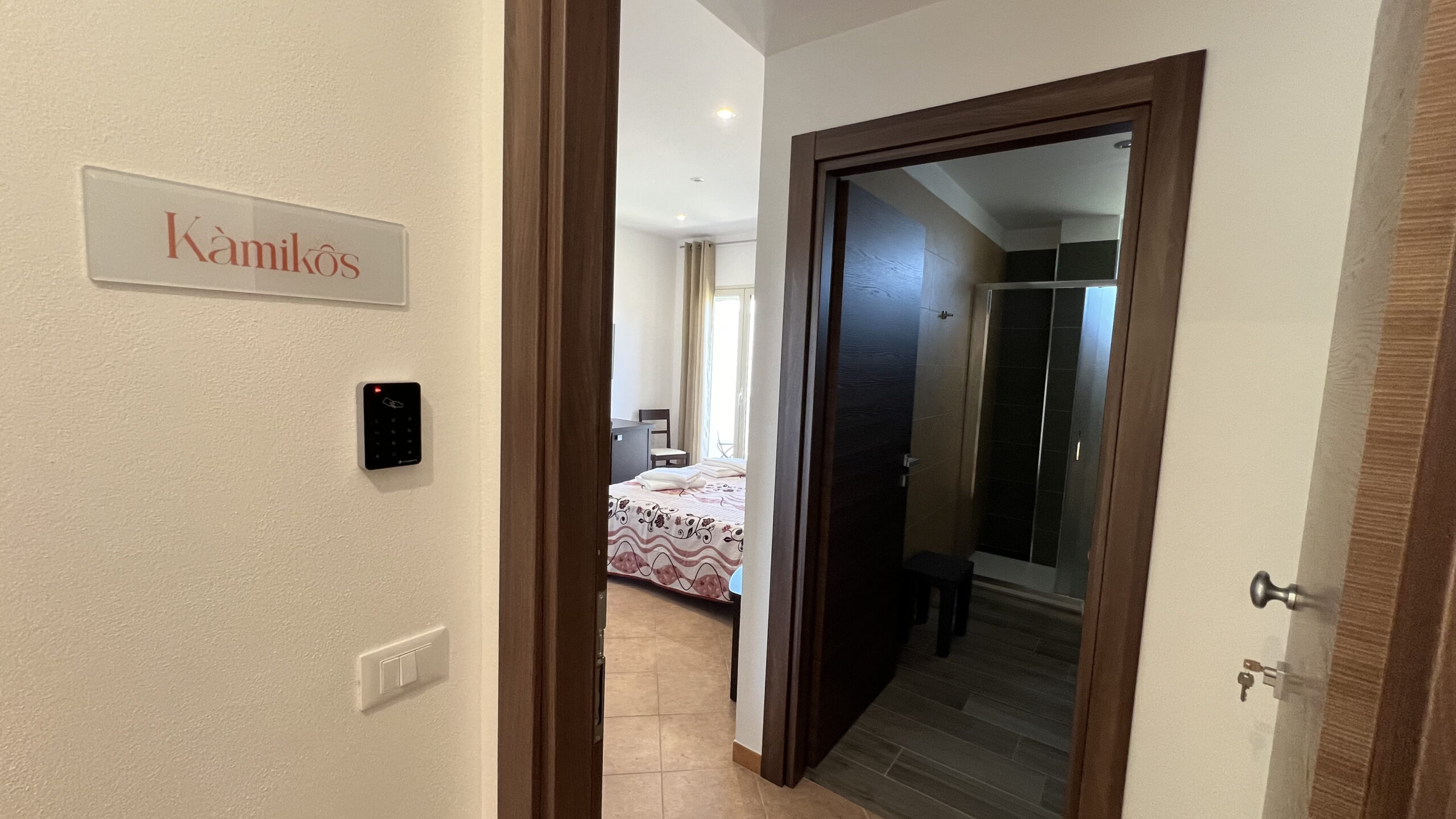 Dettaglio della porta con sistema di apertura domotica della camera Kamikos Jenka.